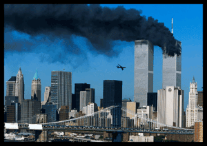 Smoke rising from the World Trade Center during the September 11 attacks in New York City, with the Twin Towers burning and a plane flying towards the buildings.