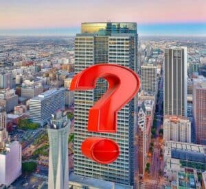 Question mark over a cityscape skyscraper during sunset showing uncertainty or inquiry, symbolizing questions or analysis in urban environments.