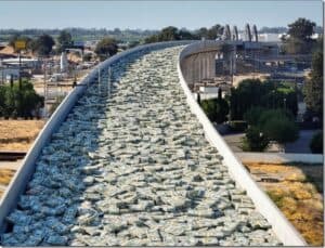 Stacks of U.S. dollar bills piled on a winding highway bridge, symbolizing economic growth or financial excess.