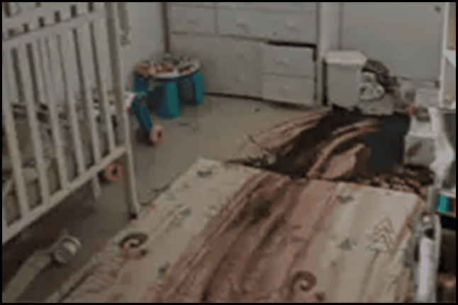 Messy baby nursery with scattered toys, bedding, and a playpen, showcasing a cluttered child's room. Perfect for discussions on home organization, parenting tips, or child safety.