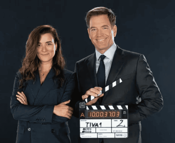 People in professional attire holding a movie clapperboard on a dark background.