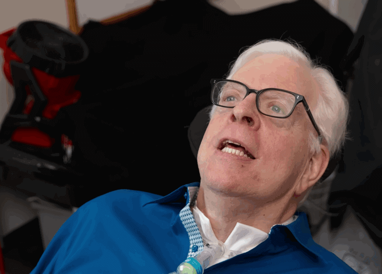 Critically ill man with a tracheostomy speaking at a press conference, emphasizing issues related to healthcare and public safety, highlighting the importance of awareness and advocacy.