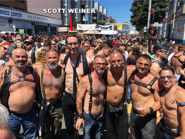 SCOTT WEINER at a Pride parade, surrounded by a large crowd of LGBTQ+ participants, showcasing diversity, pride, and celebration of LGBTQ+ rights, with a focus on inclusivity and equality.